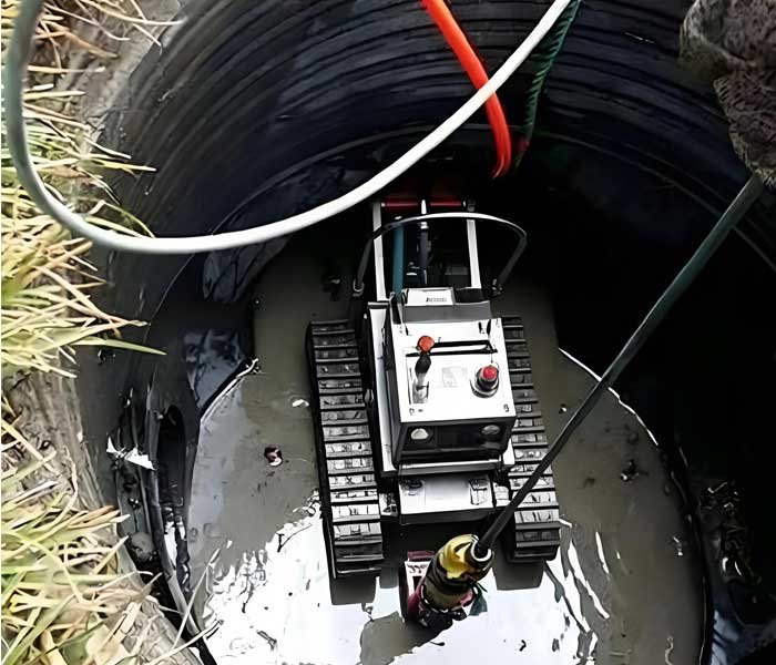 Wet well cleaning robot removing accumulated sewage solids from a deep municipal wet well