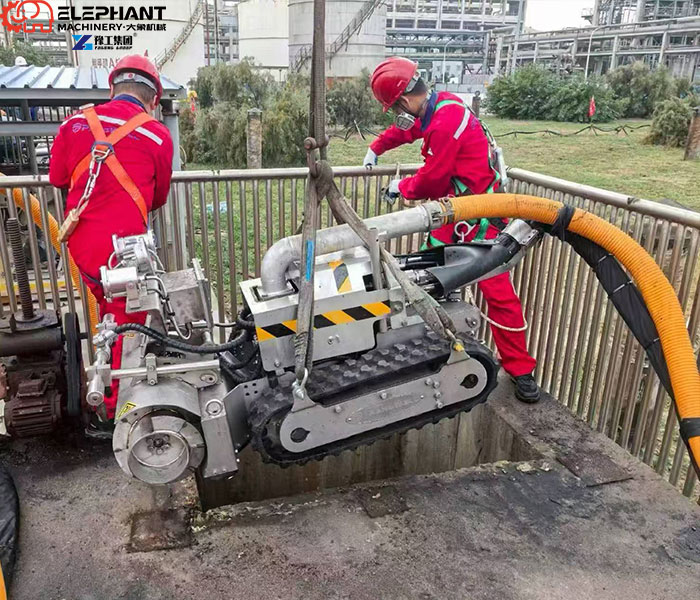 Sludge removal robot entering a wastewater tank through a manhole
